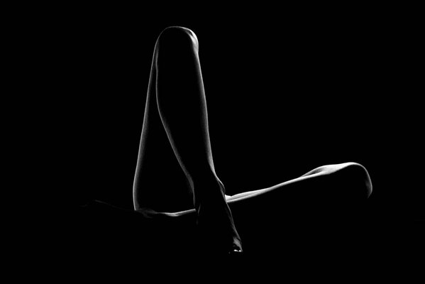 Silhouette of female legs on a black background