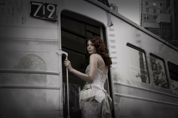 The girl holds on to the railing of the car