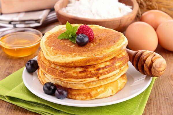 Pancakes with berries and cottage cheese , on the table