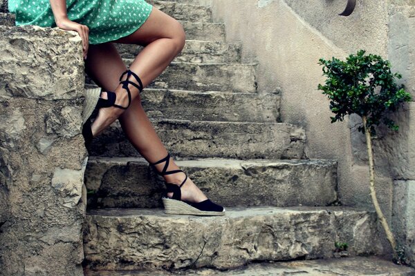 Pieds féminins sur un escalier en pierre