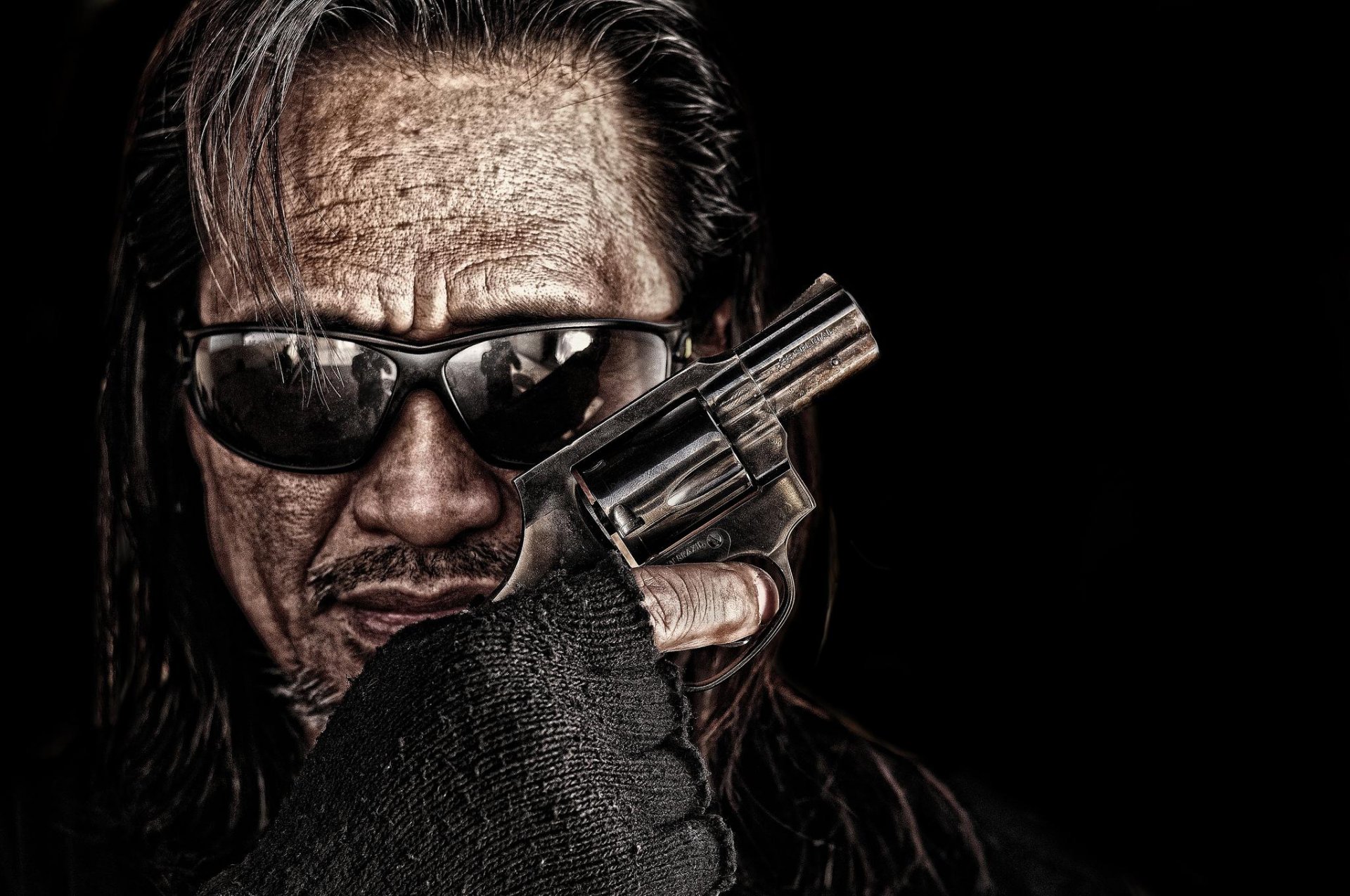 a man face sunglasses revolver weapon hand