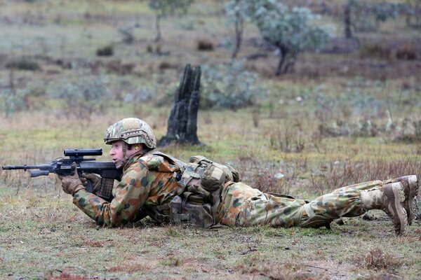 A soldier with a weapon in ambush lies on his stomach