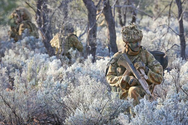 Soldaten in Uniform zwischen Bäumen und Blumen