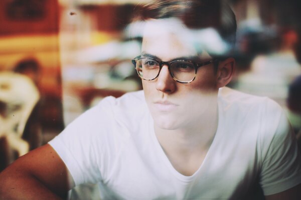 Jeune homme à lunettes et t-shirt blanc