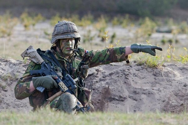 Soldado con armas en la trinchera