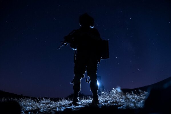 An armed soldier against the sky