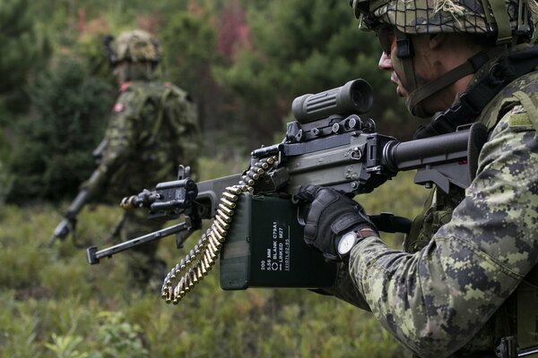 Soldat en uniforme avec des armes dans la forêt