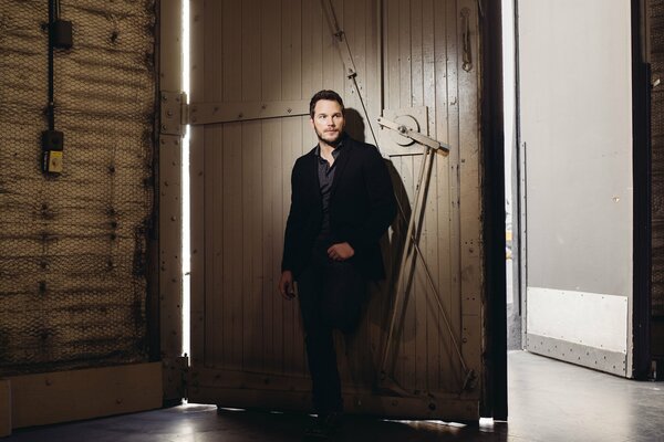 Chris Pratt at the barn gate in a black jacket