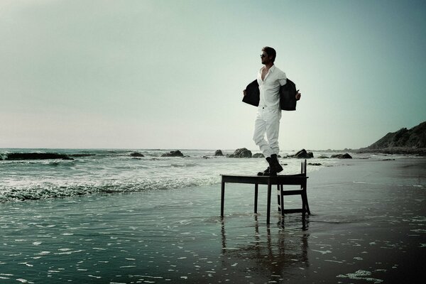 Chris Hemsworth sur la table qui se tient sur la plage