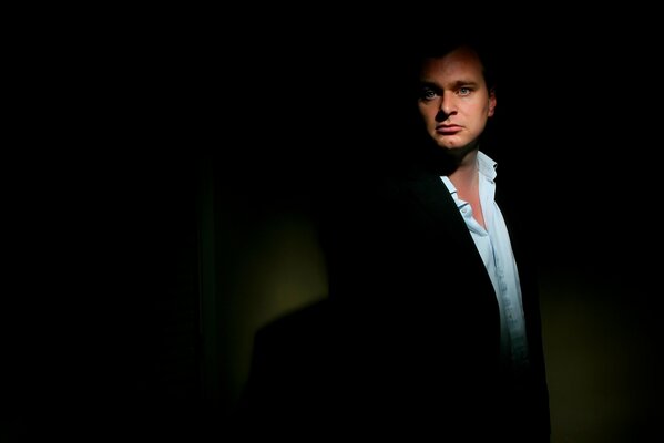 Director Christopher Nolan on a dark background