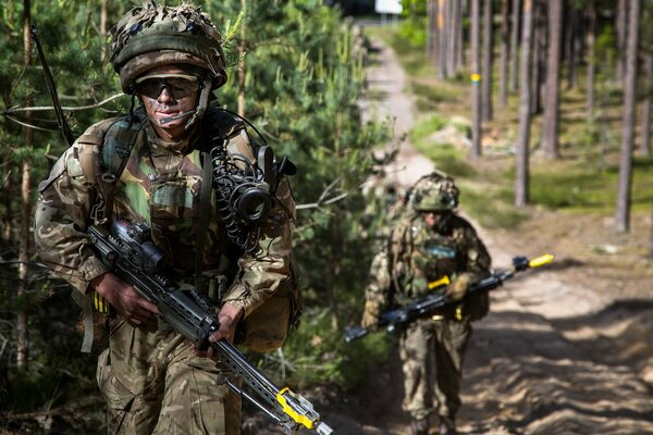 Zwei Soldaten gehen die Straße im Wald entlang