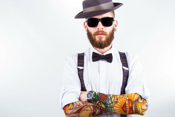 Stile classico uomo con tatuaggio sulle braccia