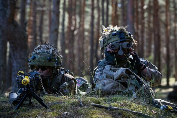 Maskierte Soldaten mit Geschützen suchen nach dem Ziel