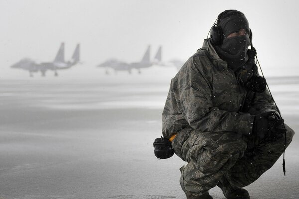 Homme en uniforme sur le terrain de vol en hiver