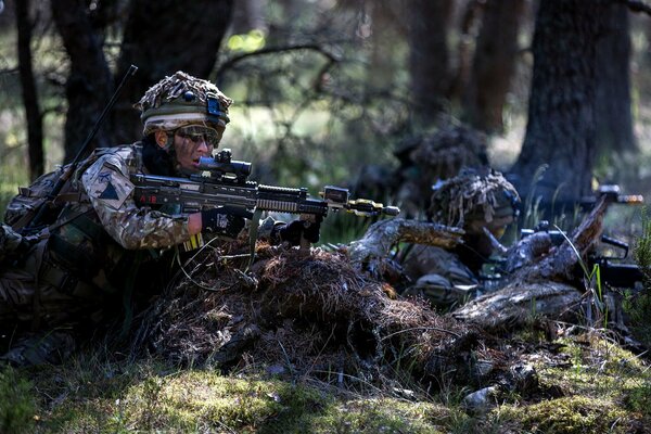 Los soldados se sientan en una emboscada con armas