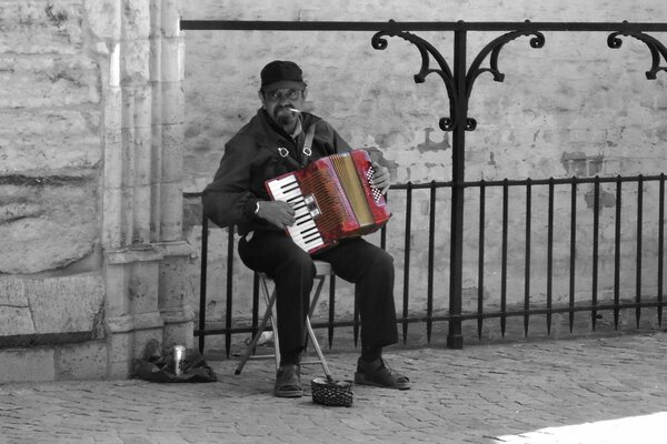 A musician with an accordion is playing outside