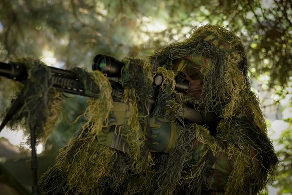 Sniper avec un fusil déguisé en vert