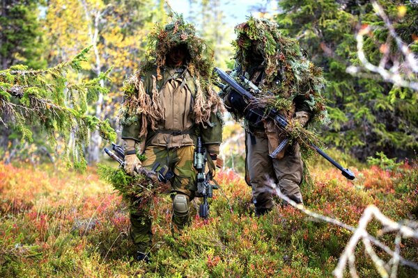 Maskierte Soldaten mit Waffen stehen