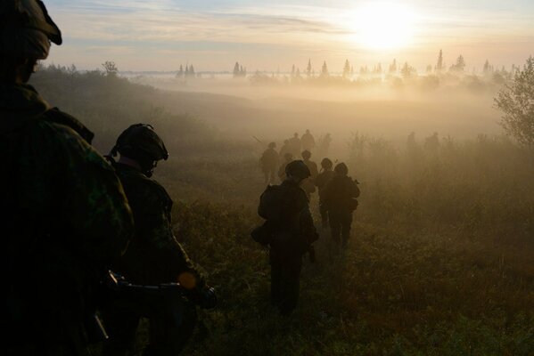 Los soldados se van en la niebla de la mañana