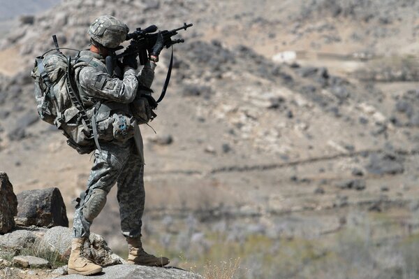 Soldat avec des armes debout sur la rive rocheuse