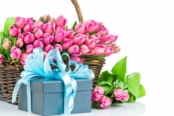 A basket of bright pink tulips and a gift box