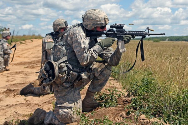 Drei Soldaten mit Waffen im Feld