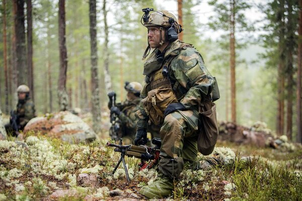 Trois soldats inspectent la forêt en tenue