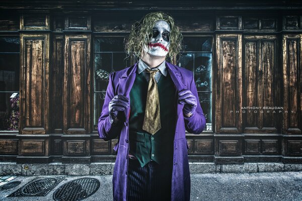 Joker se tient dans un manteau violet