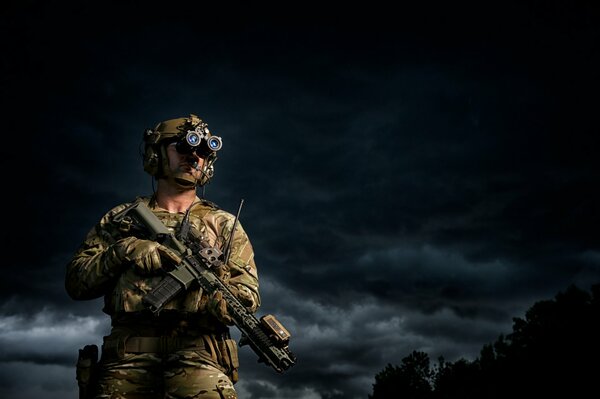 A soldier in full gear against a black sky