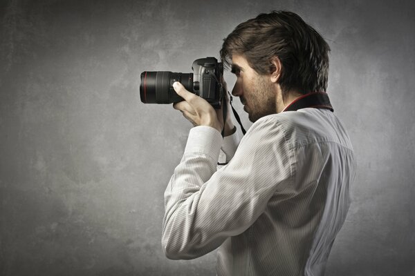 Ragazzo in camicia bianca con la macchina fotografica