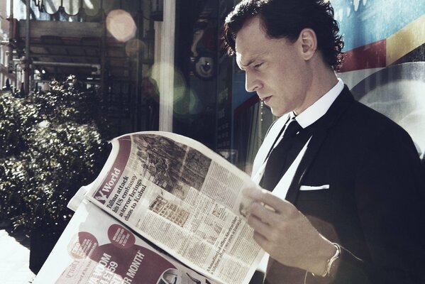 Actor Hiddleston reads the newspaper