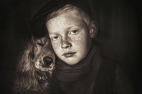 Portrait of a boy with freckles and a long-eared dog in sepia color