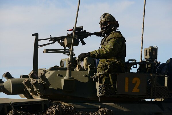 Żołnierz na czołgu w pobliżu karabinu maszynowego