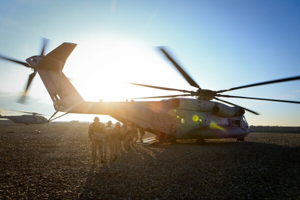 Hélicoptère avec une armée de soldats sur le terrain