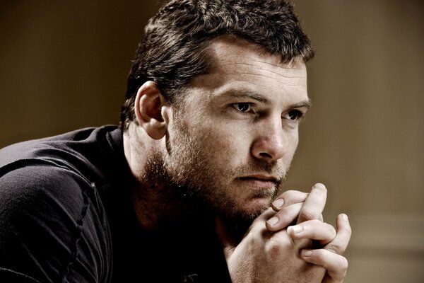 Un hombre con una mirada pensativa. el actor Sam Worthington