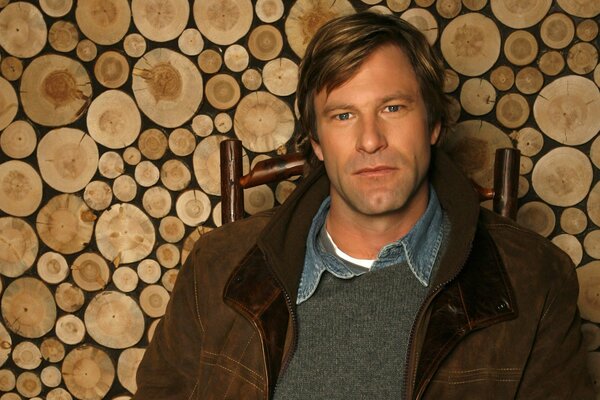 Aaron eckhart im Hintergrund des Brennholzes