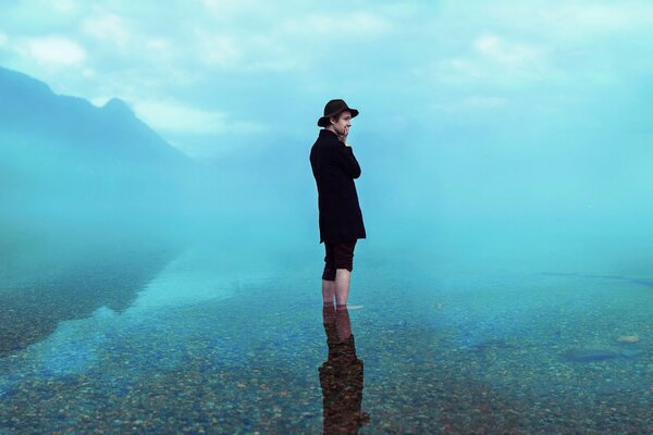 Hombre con sombrero con reflejo en el agua