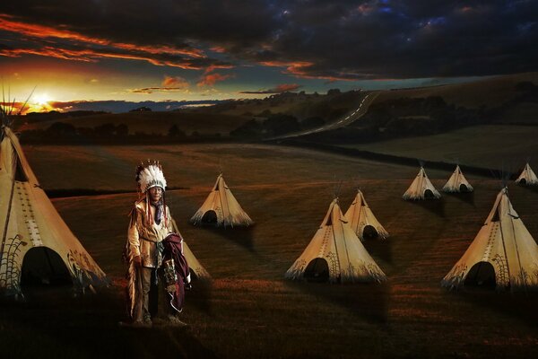 Indianer und Wigwams bei Sonnenuntergang Hintergrund