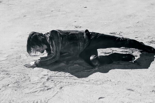 Norman Reedus poses on the sand during a photo shoot