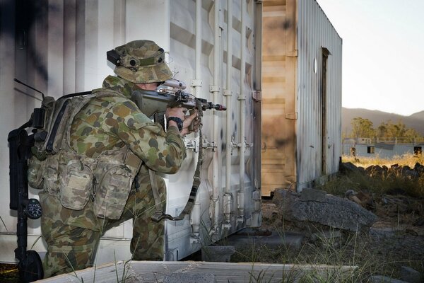 An armed soldier, looking through the scope