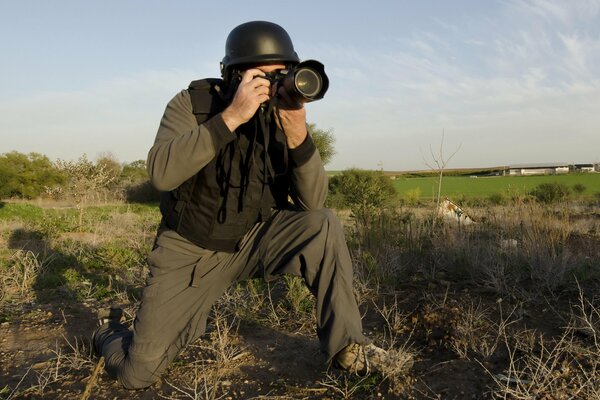 Foto di un corrispondente di guerra con una macchina fotografica sul campo