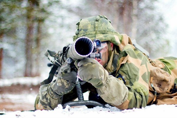 Ein Soldat mit einer Waffe auf dem Boden. Die Armee