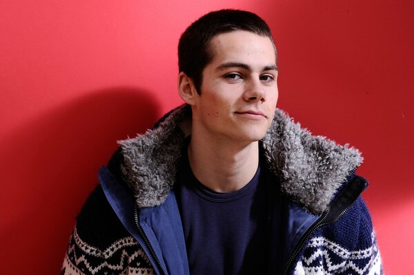 Dylan Obrien poses by the red wall