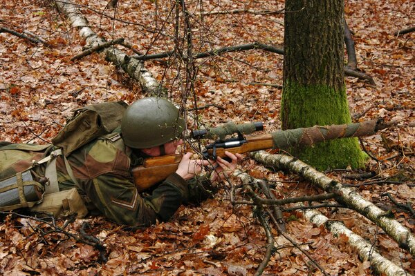 Sniper in ambush on autumn foliage