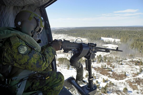 Soldat mit Maschinengewehr im Flugzeug über Wald