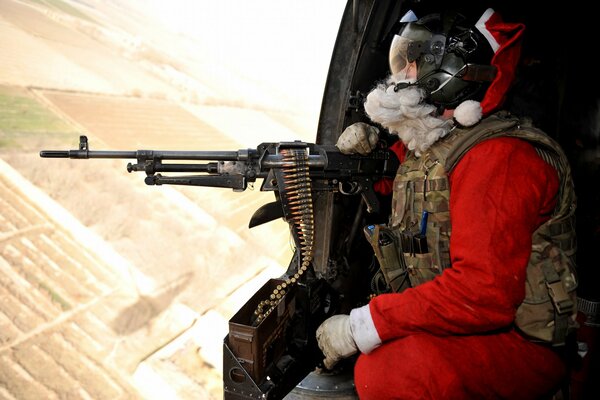 A soldier in a Santa costume with a gun in his hands