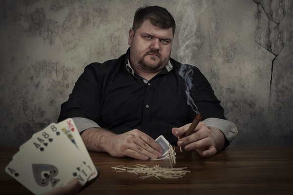 Juego de póquer. Hombre con cigarros y cartas