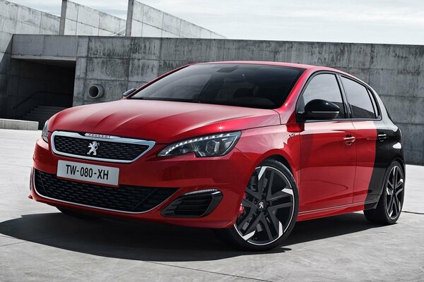 A red Peugeot car on a beautiful playground with unusual headlights