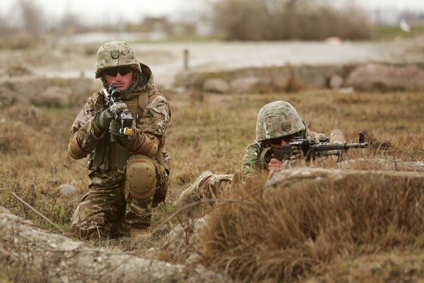 Zdjęcie przedstawia dwóch żołnierzy w mundurach