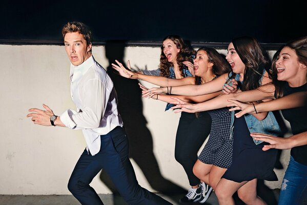 Benedict Cumberbatch runs away from female fans at a photo shoot